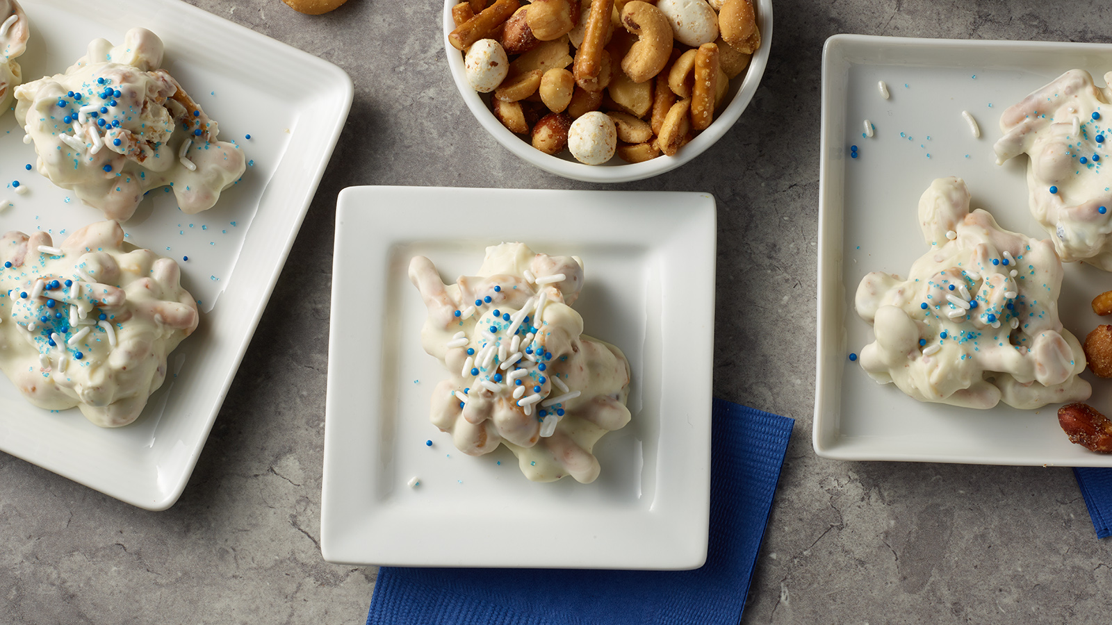 Small plates of brittle nut medley candy clusters.