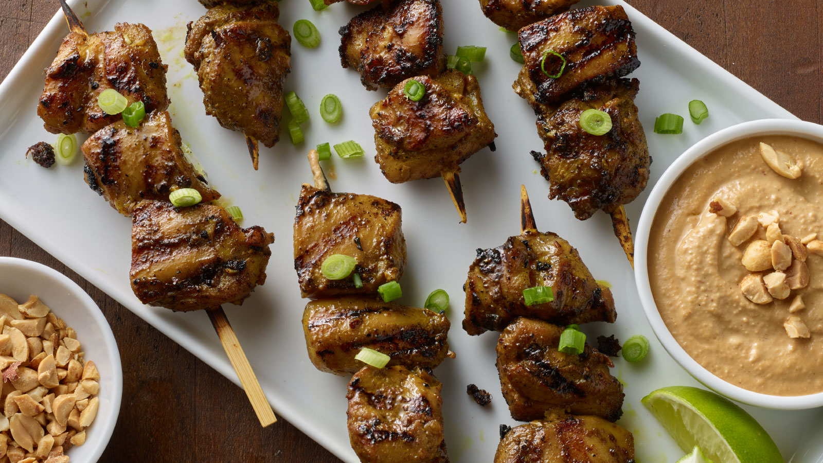 Platter with grilled chicken satay and peanut sauce.
