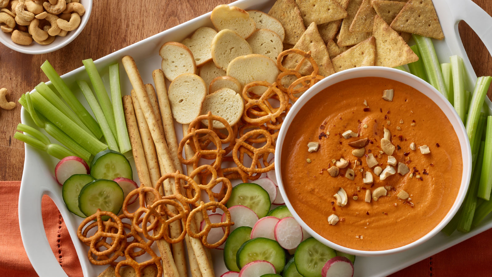 Snack platter with a bowl of roasted red bell pepper cashew dip.