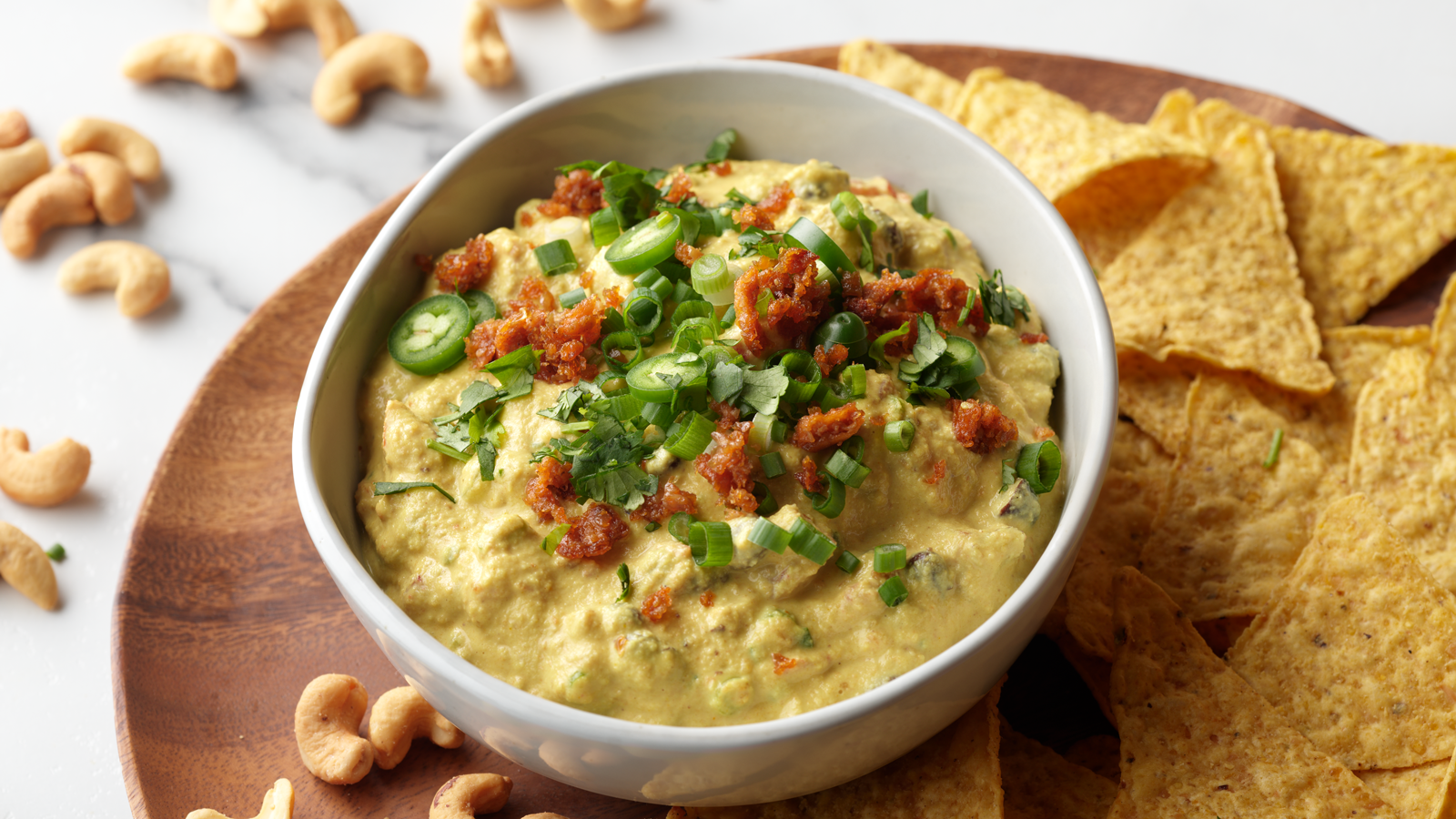 Bowl of vegan cashew loaded queso dip with tortilla chips.