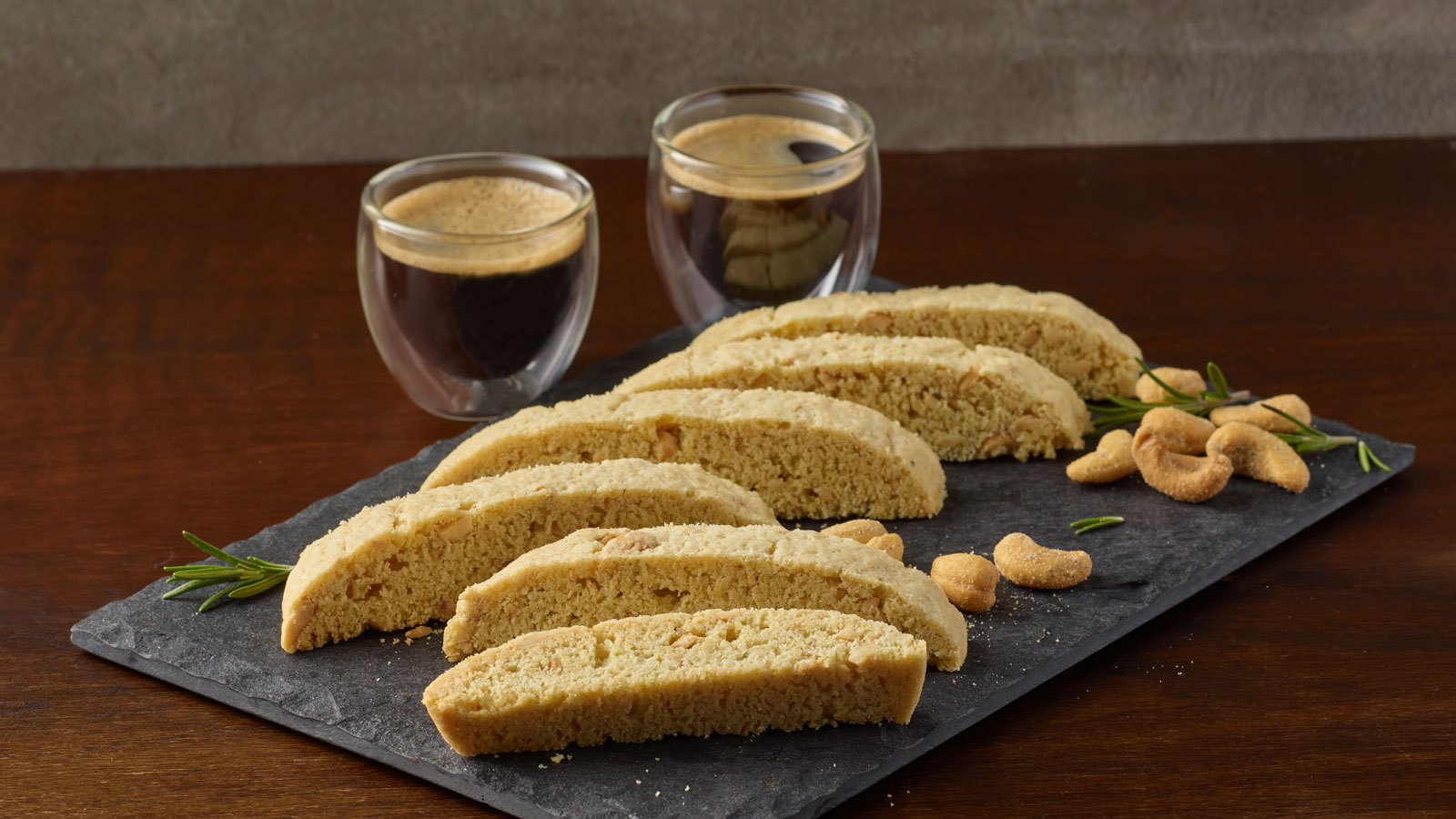 Rosemary and sea salt cashew biscotti slices on a stone slab.