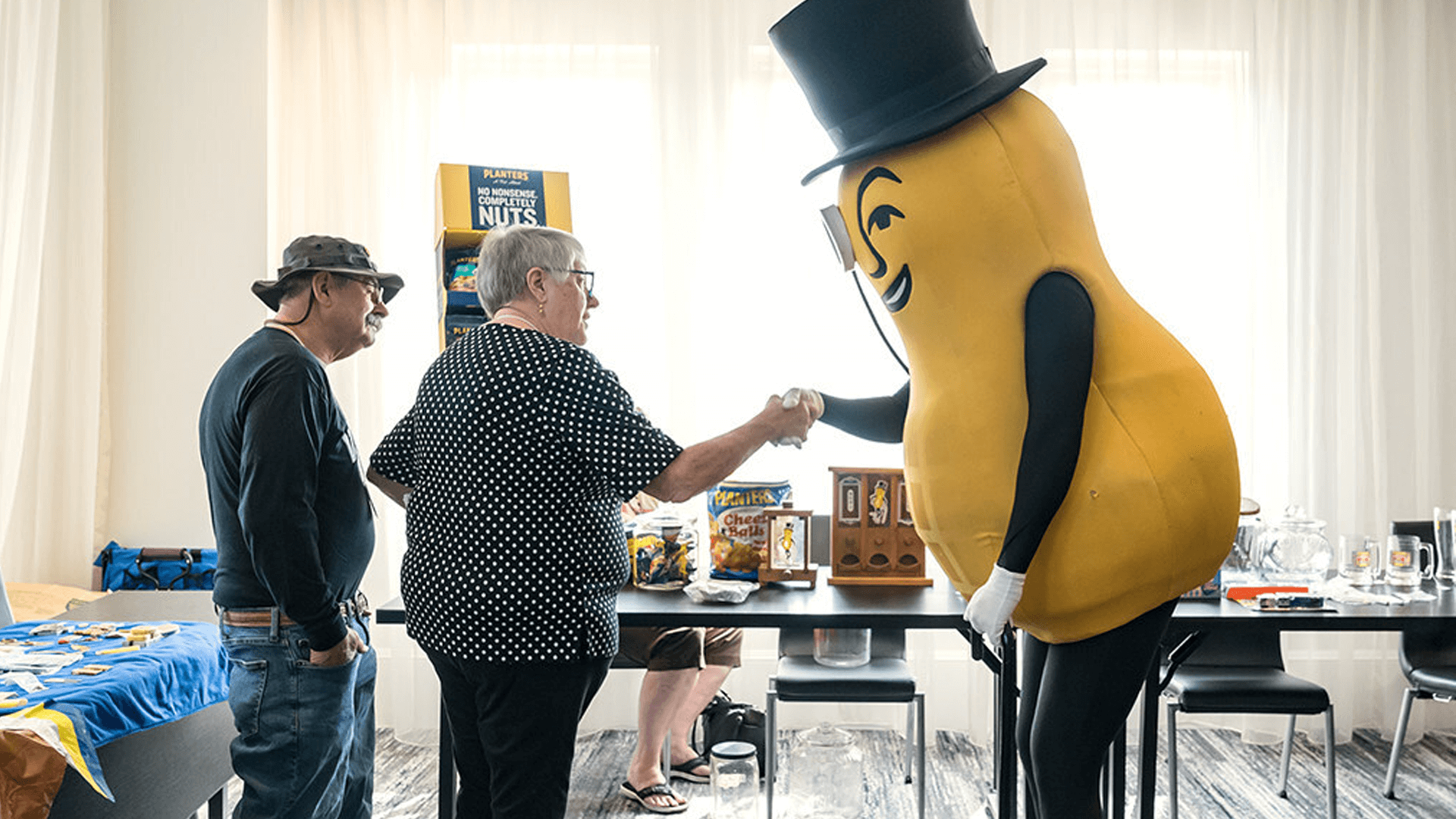 Two people shake hands with Mr Peanut