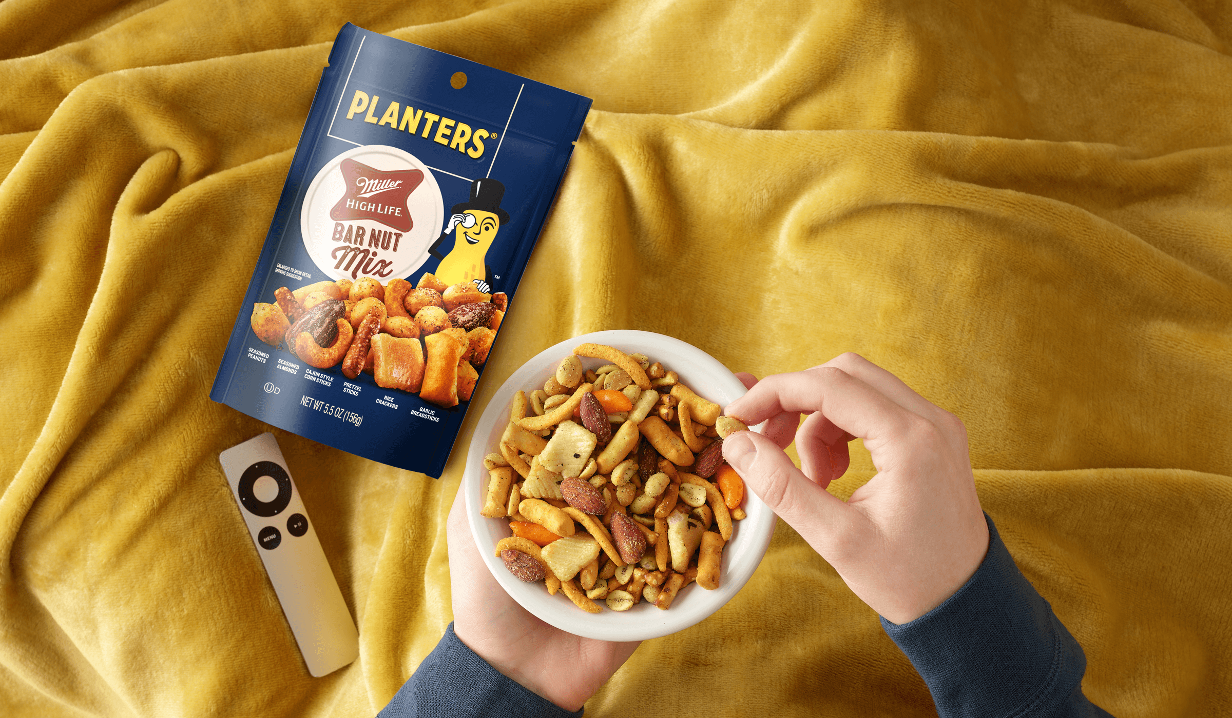overhead view of a person eating the bar nut mix with a blanket
