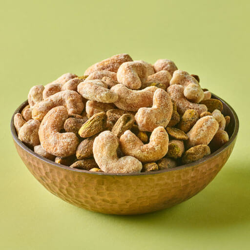 Promotional photo of planters duos peppercorn pistachios and parmesan cashews on a green background