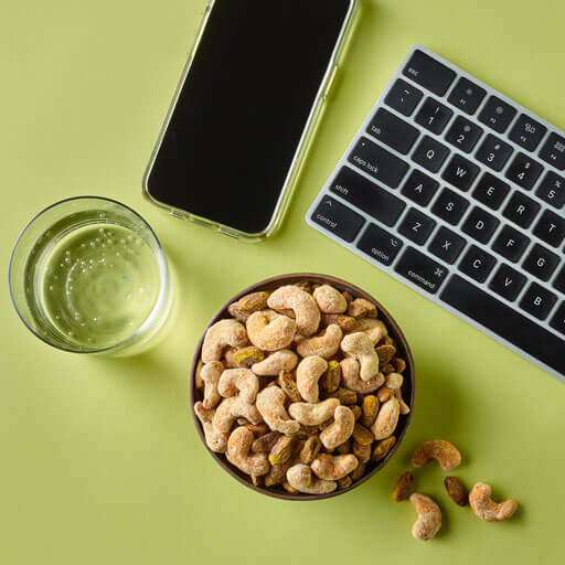 A bowl of nuts amongst a workspace with a green background