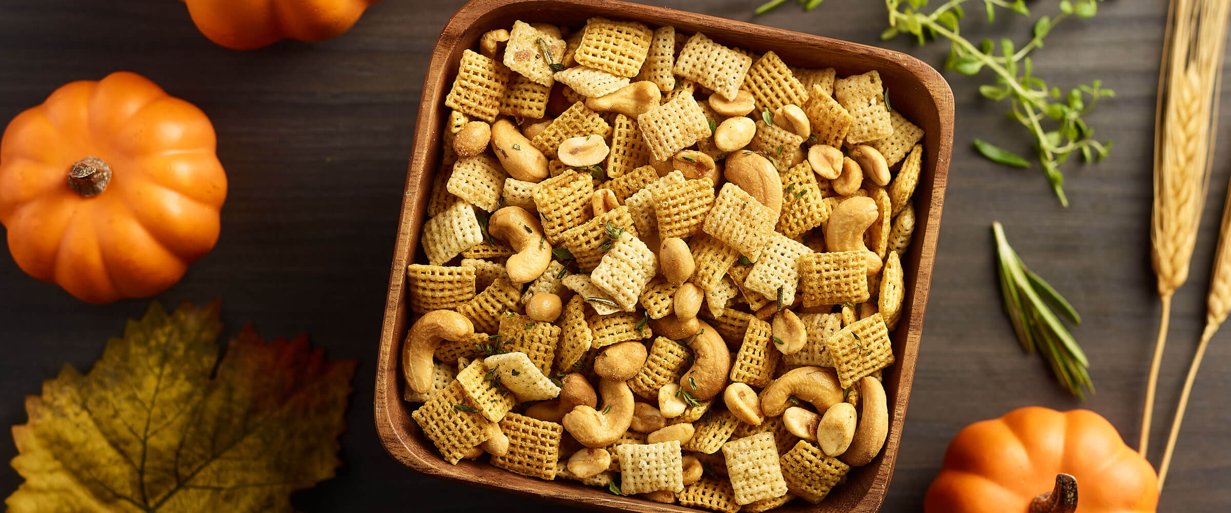 garlic herb snack mix overview of the recipe in a dish with fall decor in the background