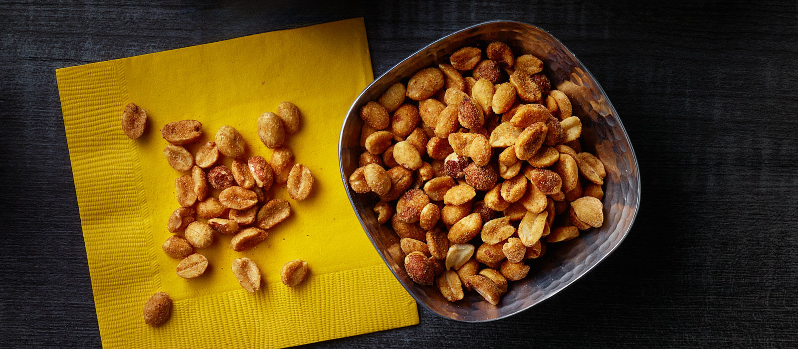 Bold and savory dry roasted peanuts in a bowl and on a baking sheet