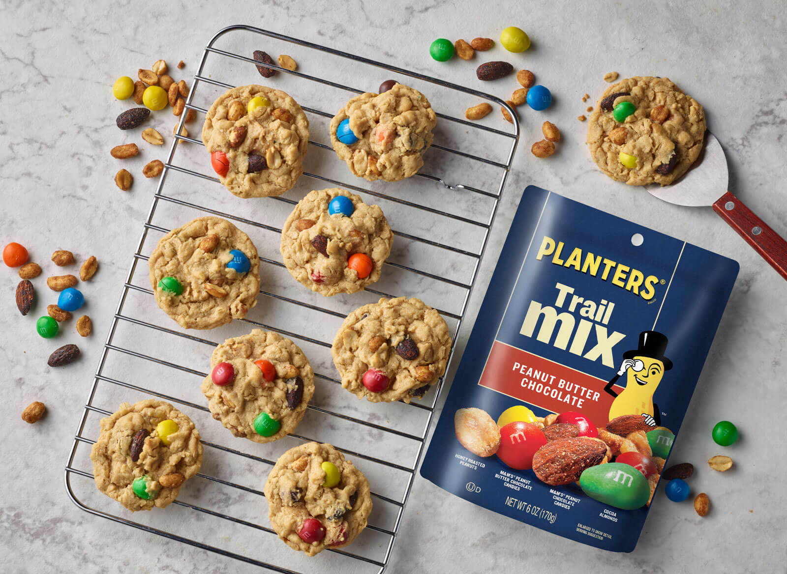 Overhead view of a trail mix package and cookies on a cooling tray
