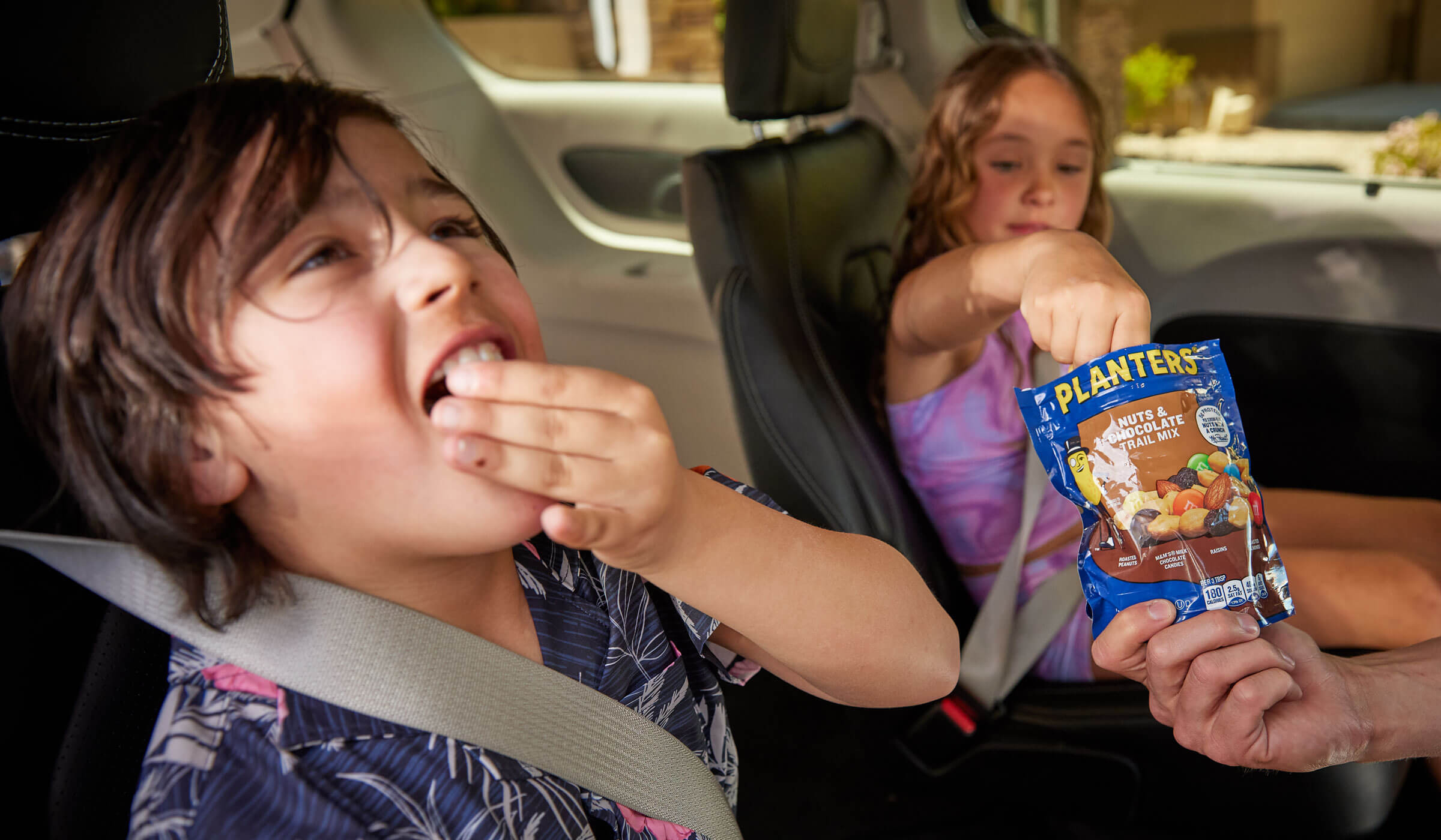 Children eating trail mix in a car