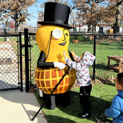 Mr Peanut hugging a small child