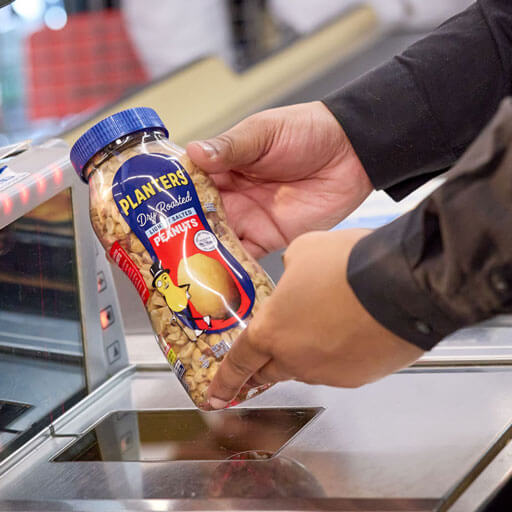 Person scanning planters dry roasted peanuts in the grocery store