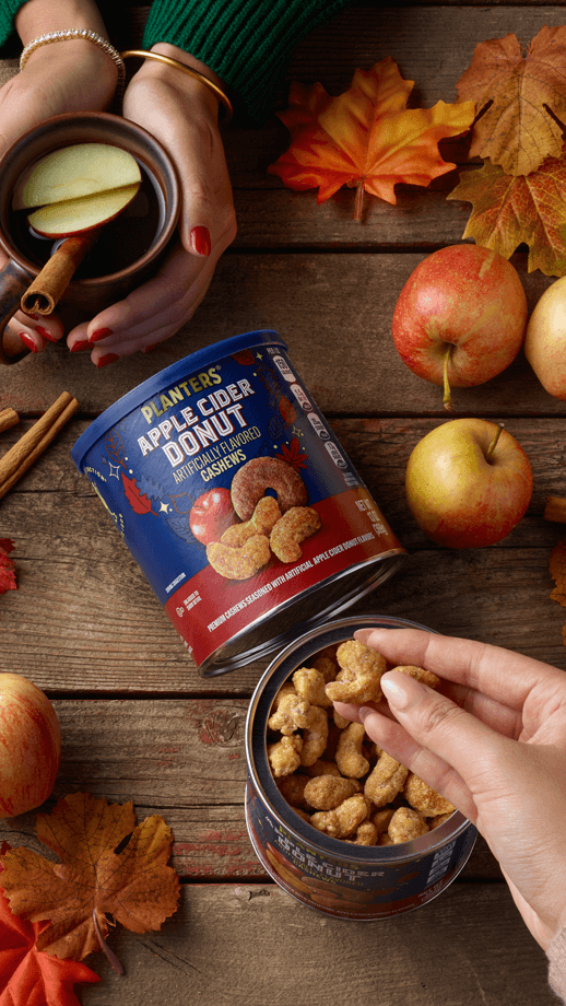 Apple cider cashews on a counter with apples