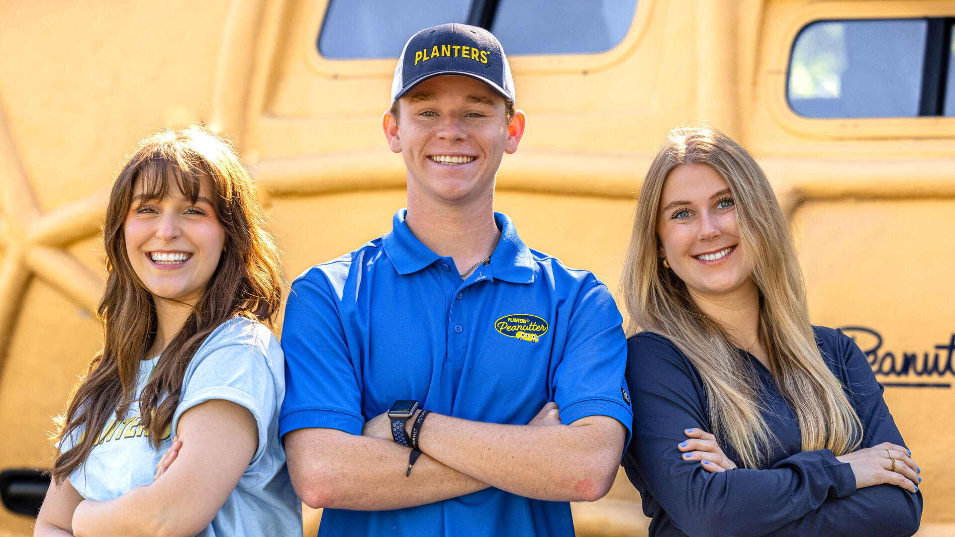 Three people smiling in front of the planters nutmobile